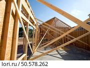 A new home being built with wood, trusses, supports and a foundation. Стоковое фото, агентство Ingram Publishing / Фотобанк Лори