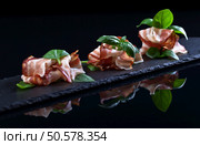 smocked bacon with green basil on a black  background. Стоковое фото, агентство Ingram Publishing / Фотобанк Лори
