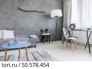 Grey living room in minimalist style with sofa, small table, two chairs, desk, and floor lamp. Стоковое фото, агентство Ingram Publishing / Фотобанк Лори