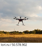 Drone on a background of a beautiful sunset. UAV in flight. Quadrocopters on radio.. Oktokopter, copter, drone. Стоковое фото, агентство Ingram Publishing / Фотобанк Лори