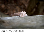 Grabing onto a small handhold, a climber makes his way to the top. His hand is covered in chalk, and there is a very shallow depth of field. The white specks are small pieces of chalk dust flying through the air. Стоковое фото, агентство Ingram Publishing / Фотобанк Лори