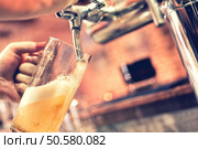 Hand of bartender pouring a large lager beer in tap. Стоковое фото, агентство Ingram Publishing / Фотобанк Лори