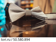 Stylish white men’s bow tie on a glass show-window of shop. Стоковое фото, агентство Ingram Publishing / Фотобанк Лори