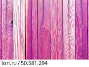 A fragment of an old wooden fence. Painted wooden planks as a background with copy space. Wooden rustic background or painted wood boards texture. Old peeling pink paint. Стоковое фото, агентство Ingram Publishing / Фотобанк Лори
