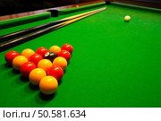 A green cloth billiards or pool table with english league red and yellow balls. Стоковое фото, агентство Ingram Publishing / Фотобанк Лори