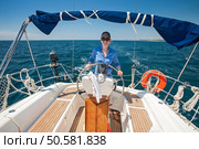 Young woman standing at the helm of a boat against a blue sky. Стоковое фото, агентство Ingram Publishing / Фотобанк Лори