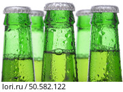 Closeup of Five Green Beer Bottles necks only with condensation over white background. Стоковое фото, агентство Ingram Publishing / Фотобанк Лори