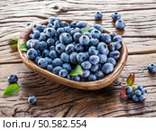 Ripe blueberries in the bowl on the wooden table. Стоковое фото, агентство Ingram Publishing / Фотобанк Лори