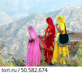 Indian women in colorful saris looking from top of hill. Стоковое фото, агентство Ingram Publishing / Фотобанк Лори