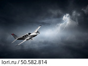 Aeroplane flying in storm with lightning (Concept of risk - digital artwork). Aeroplane flying in storm (digital artwork) Стоковое фото, агентство Ingram Publishing / Фотобанк Лори