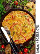 Frittata made of eggs, potato, bacon, paprika, parsley, green peas, onion, cheese in iron pan on wooden table. Frittata made of eggs, potato, bacon, paprika, parsley, green peas, onion, cheese in iron pan. on wooden table. Стоковое фото, агентство Ingram Publishing / Фотобанк Лори