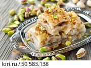 eastern traditional dessert with nuts and pistachios on wooden background. Стоковое фото, агентство Ingram Publishing / Фотобанк Лори