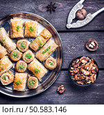 Turkish baklava near walnuts and nutcracker on wooden background  . Стоковое фото, агентство Ingram Publishing / Фотобанк Лори