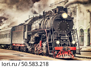 Retro steam train departs from the station.. Retro steam train. Стоковое фото, агентство Ingram Publishing / Фотобанк Лори