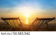 Two sunbeds on the sea beach during sunset. Стоковое фото, агентство Ingram Publishing / Фотобанк Лори