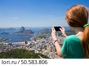 girl tourist  takes a picture of  Rio landscape and Pao de Asucar with smartphone. Стоковое фото, агентство Ingram Publishing / Фотобанк Лори