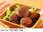 Scoops of chocolate ice cream and shavings in wooden bowl. Стоковое фото, агентство Ingram Publishing / Фотобанк Лори