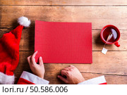 Santa Claus holding an empty wish list in his hands. Santa Claus and wishlist. Стоковое фото, агентство Ingram Publishing / Фотобанк Лори