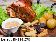 Appetizing roast pork knuckle on cutting board. pork knuckle. Стоковое фото, агентство Ingram Publishing / Фотобанк Лори