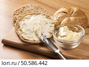 A knife spreading butter on bread. Стоковое фото, агентство Ingram Publishing / Фотобанк Лори