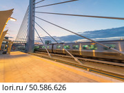 Train speeding up on a station at sunset. Стоковое фото, агентство Ingram Publishing / Фотобанк Лори