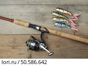 lot of colorful lures with the fishing rod on the wooden pier. Стоковое фото, агентство Ingram Publishing / Фотобанк Лори