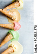 Colorful ice cream cones of different flavors. Melting scoops. Top view, copy space, steel metal background. Colorful ice cream cones of different flavors. Melting scoops. Top view,  steel metal background. Стоковое фото, агентство Ingram Publishing / Фотобанк Лори
