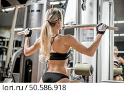 young fitness woman execute exercise with exercise-machine in gym, horizontal photo. Стоковое фото, агентство Ingram Publishing / Фотобанк Лори