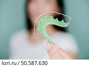 Asian woman holding orthodontic retainers.Teeth retaining tools after braces . Стоковое фото, агентство Ingram Publishing / Фотобанк Лори