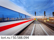 High speed passenger train on tracks in motion at sunset. Commuter train. Railway station in Nuremberg, Germany. Railroad with vintage toning. Стоковое фото, агентство Ingram Publishing / Фотобанк Лори