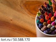 Crayons in a white mug sitting on a wooden desk. Стоковое фото, агентство Ingram Publishing / Фотобанк Лори