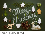 Merry Christmas greeting text on a chalkboard decorated with various Christmas staff, flat lay, view  from above, stylized photo. Стоковое фото, агентство Ingram Publishing / Фотобанк Лори