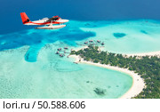 Sea plane flying above Maldives islands, Raa atol. Sea plane flying above Maldives islands. Стоковое фото, агентство Ingram Publishing / Фотобанк Лори