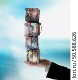 Businessman’s hand holding stack of gift boxes made of world currencies. 24316757. Стоковое фото, агентство Ingram Publishing / Фотобанк Лори
