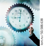 Businessman touching cog wheel with clock face in center. 24316770. Стоковое фото, агентство Ingram Publishing / Фотобанк Лори