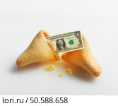 Broken fortune cookie with US Dollar inside. 24316790. Стоковое фото, агентство Ingram Publishing / Фотобанк Лори