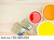 opened paint cans with brushes on wooden background. Стоковое фото, агентство Ingram Publishing / Фотобанк Лори