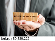 Close,Up,Conceptual,Businessman,Showing,Wooden,Blocks,With,Believe,In. Стоковое фото, агентство Ingram Publishing / Фотобанк Лори