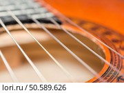 Detail of classic acoustic guitar with shallow depth of field.. Detail of classic acoustic guitar with shallow DOF and blur. Стоковое фото, агентство Ingram Publishing / Фотобанк Лори