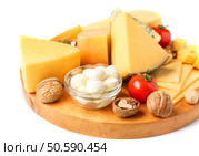 Board with assortment of delicious cheese, tomatoes and nuts on white background. Стоковое фото, агентство Ingram Publishing / Фотобанк Лори
