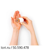 Girl pours colorful sugar sprinkle dots out of eggshell on spring decoration background. Easter concept. Flat lay, top view. Стоковое фото, агентство Ingram Publishing / Фотобанк Лори