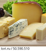 Different cheeses served on wooding cutting board. Стоковое фото, агентство Ingram Publishing / Фотобанк Лори