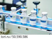 pharmaceutical industry. Production line machine conveyor with glass bottles ampoules at factory . pharmaceutical glass bottles production line . Стоковое фото, агентство Ingram Publishing / Фотобанк Лори