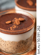 Delight in a luscious tiramisu-inspired chia pudding, layered with creamy coffee-infused chia and a rich chocolate topping. This guilt-free breakfast or dessert option blends classic flavors with wholesome ingredients for a convenient and satisfying treat. Стоковое фото, агентство Ingram Publishing / Фотобанк Лори