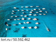 Aerial view of many motorboats on blue sea at sunset in summer. Travel in Sardinia, Italy. Drone view from above of speed boats, yachts, ocean, transparent azure water. Tropical seascape. Стоковое фото, агентство Ingram Publishing / Фотобанк Лори