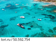 Aerial view of beautiful luxury yacht and boat in blue sea in summer. Sardinia, Italy. Top drone view of speed boat, sea coast, transparent azure water. Travel. Tropical landscape. Yachting. Seascape. Стоковое фото, агентство Ingram Publishing / Фотобанк Лори
