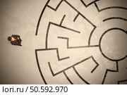 Lost business man looking for a way in circular labyrinth concept. Стоковое фото, агентство Ingram Publishing / Фотобанк Лори