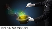 Illusionist hand starts to conjure with white glove and magic wand. Стоковое фото, агентство Ingram Publishing / Фотобанк Лори