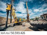 Highway construction site with heavy duty machinery. Two Rotary drills, bulldozer and excavator working. Стоковое фото, агентство Ingram Publishing / Фотобанк Лори