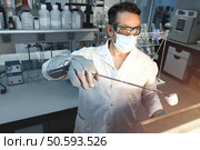 Scientist doing a test in a laboratory muffle in which a sample is calcined in a ceramic crucible. Selective focus. Стоковое фото, агентство Ingram Publishing / Фотобанк Лори